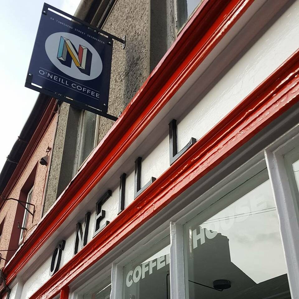The hanging O'Neill Coffee blade sign above the black lettering and red-painted fascia of the shop on Townshend Street